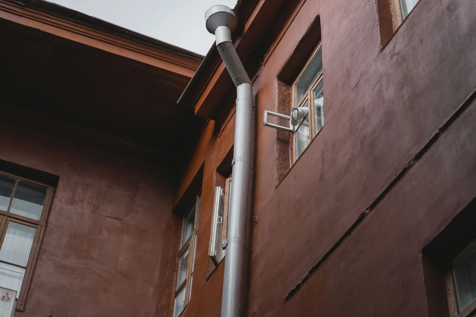 Tronçon de colonne d'évacuation en fonte ancienne dans une gaine technique d'immeuble haussmannien