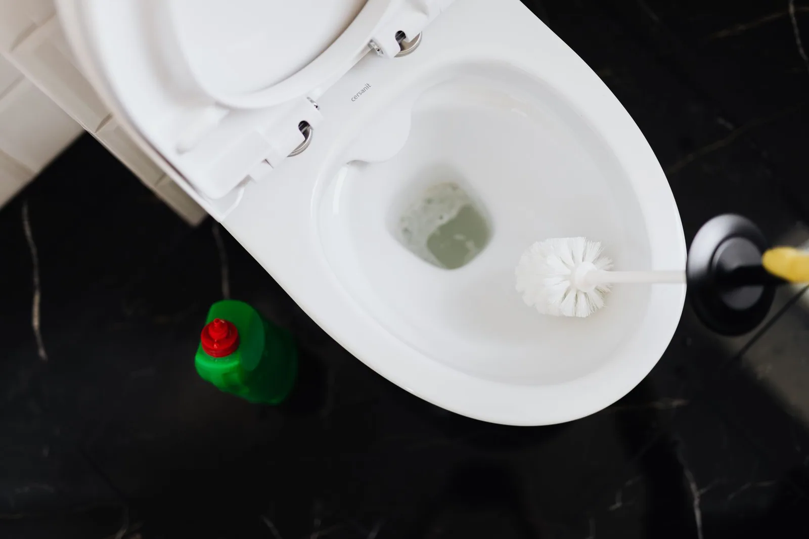 Ventouse à cloche avec jupe périphérique posée sur une cuvette de WC, le modèle adapté au débouchage des toilettes