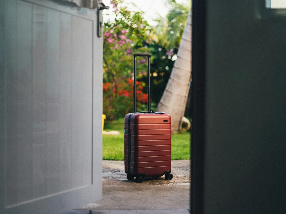 Valise devant une porte d'entrée avant un départ en vacances