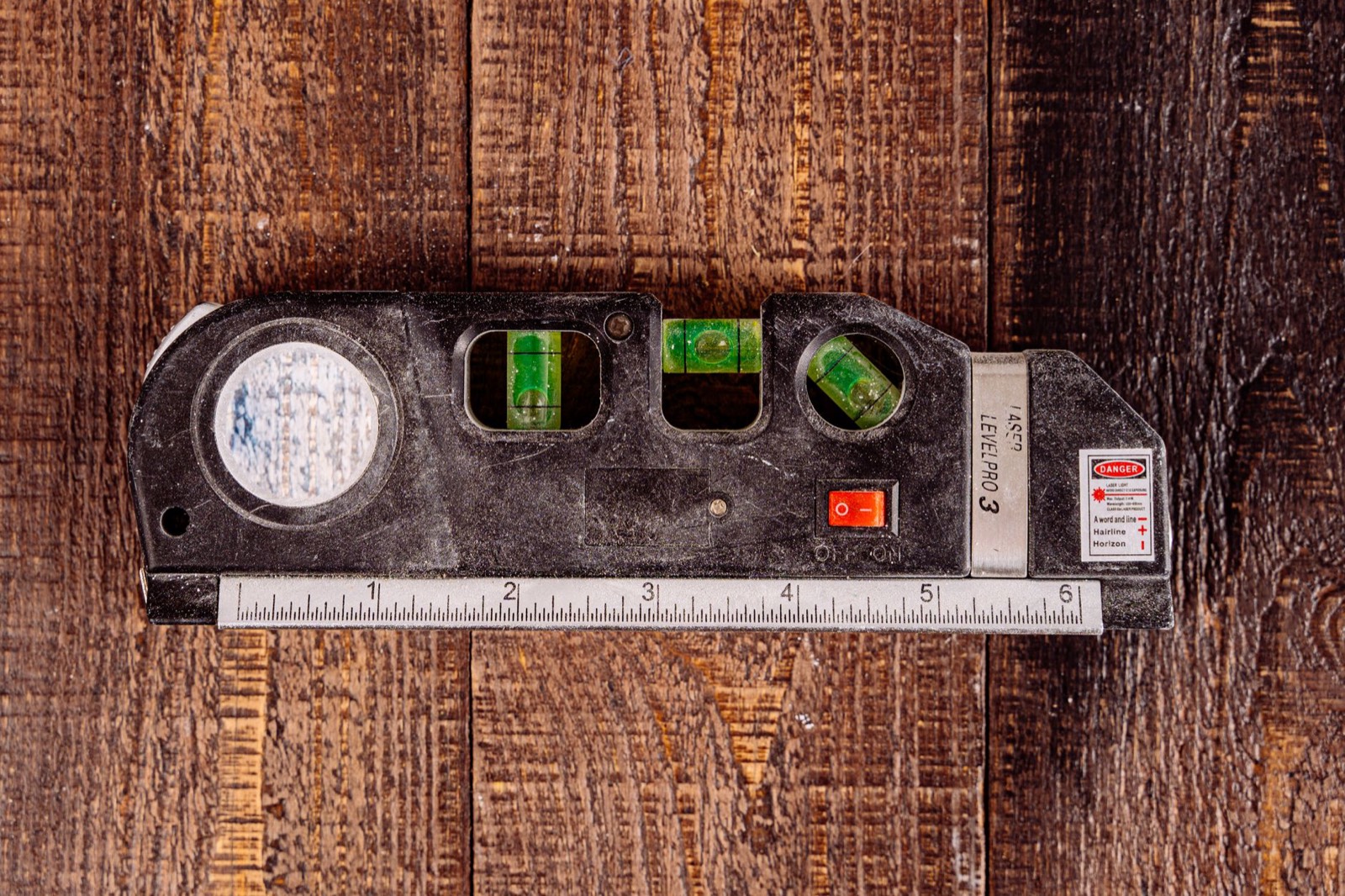 Géomètre mesurant au laser les dimensions d'une pièce d'appartement avant travaux de plomberie