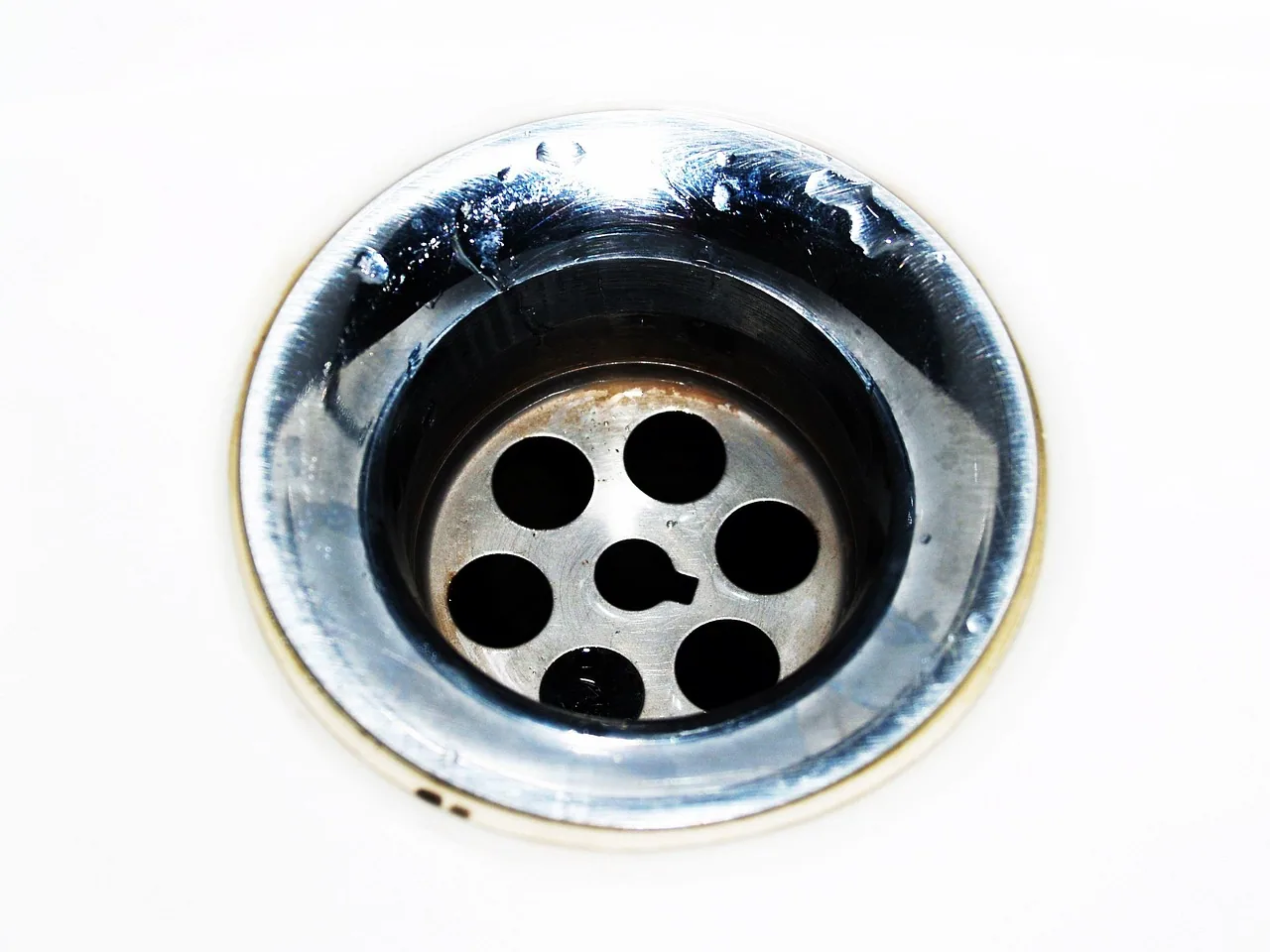 Siphon d’évier ouvert avec une bassine placée dessous pour vérifier un bouchon